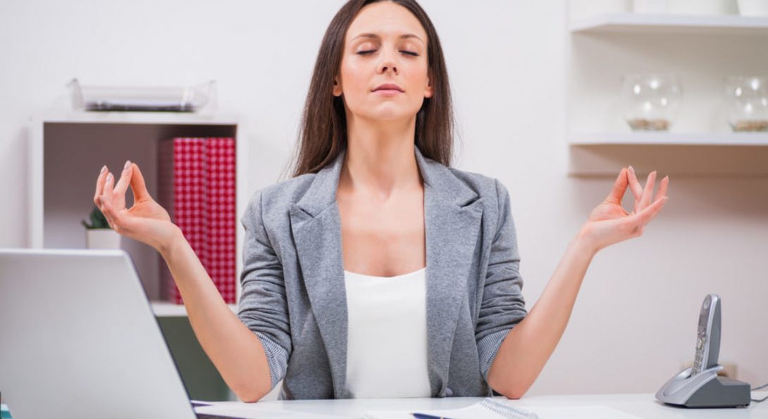 image of a woman practicing yoga at her desk